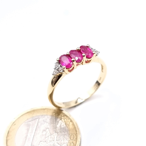 490 - Star Lot : A pretty three stone ruby ring with diamond shoulders set in 10K gold, ring size Q, weigh... 