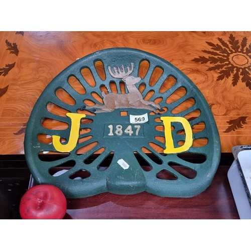 569 - A cast metal JD tractor seat painted in shades of green and yellow.