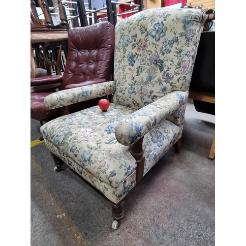 586 - A wonderful early 20th Century armchair boasting turned legs and sat on castor wheels. Upholstered i... 