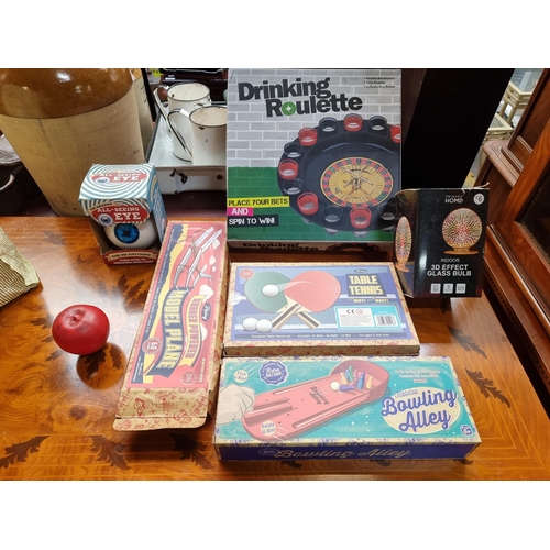 597 - A fun mixed lot of games including a shot roulette drinking game and table tennis set.