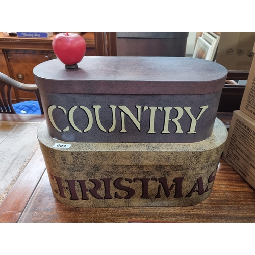 609 - Two good sized storage boxes, one reading Country and the other Christmas.