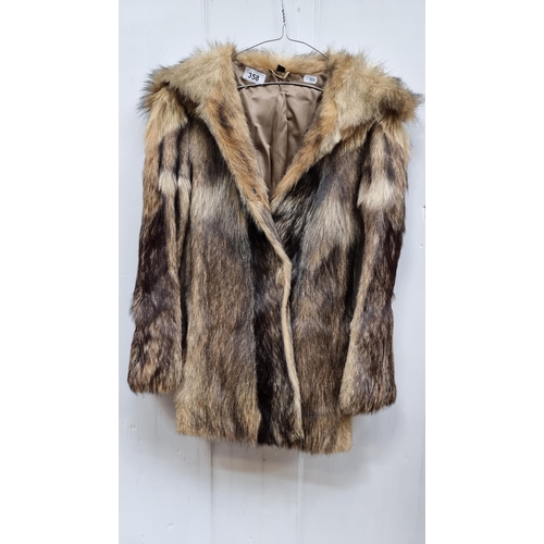 358 - A stylish genuine fur jacket in beige and black. With hook fastening and pockets. Approx. size 10/12... 