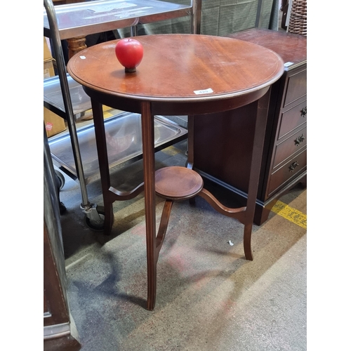 429 - A charming Edwardian side table with a round top and base with stretchers boasting a delicate string... 