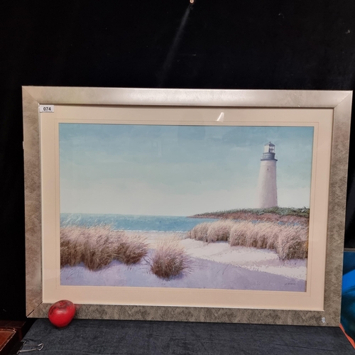 74 - A large giclee print of a J. Wiens painting. Features a coastal landscape with lighthouse. Housed in... 