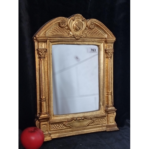 763 - A lovely Gilt mirror held in an extravagant Neoclassical style gilt frame. H43cm x W33cm