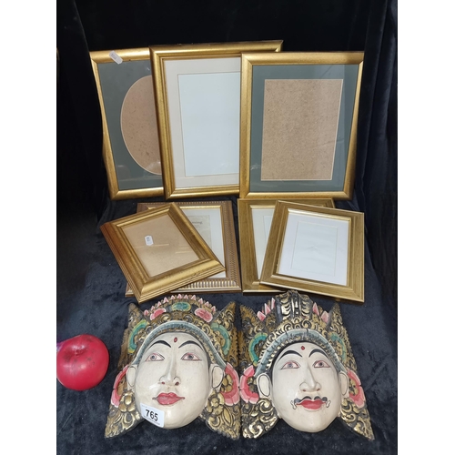 765 - Nine items including two carved wood and gilt Indian masks with 7 gilt wood photo frames. Those mask... 