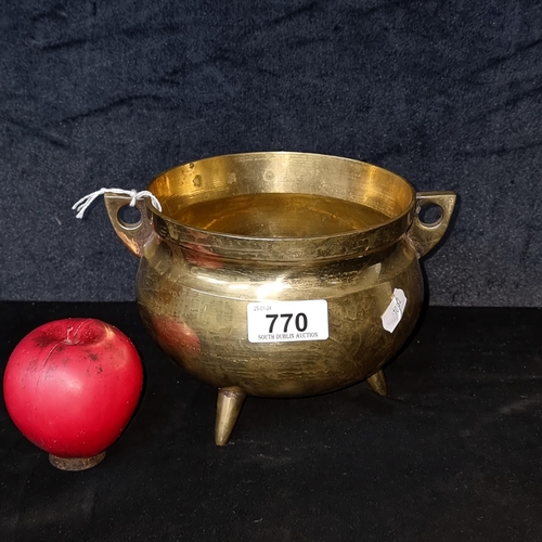 770 - A neatly sized brass cauldron with handles and three feet. Good for young witches just starting out.