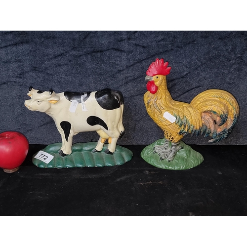 772 - Two very heavy cast metal door stoppers in the form of a cow and a rooster.