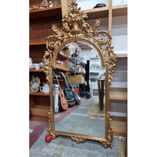 784 - Star Lot : A large highly ornate Rococo style wall mirror with beveled glass housed in extravagant g... 