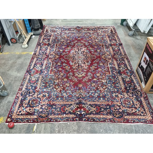 902 - Star Lot: A magnificent and large hand woven Persian style woolen rug, boasting an intricate foliate... 