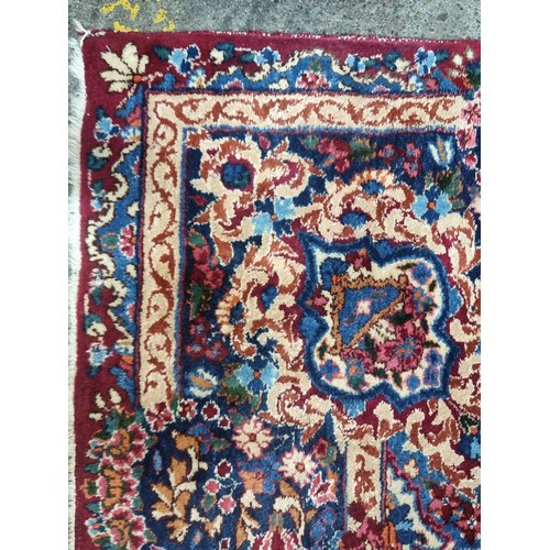 902 - Star Lot: A magnificent and large hand woven Persian style woolen rug, boasting an intricate foliate... 