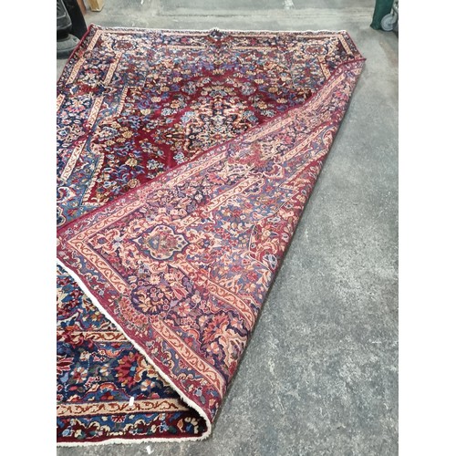 902 - Star Lot: A magnificent and large hand woven Persian style woolen rug, boasting an intricate foliate... 