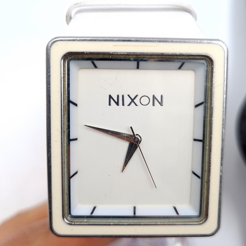 446 - A Nixon stainless steel leather strap wristwatch together with a Swatch water resistant example.