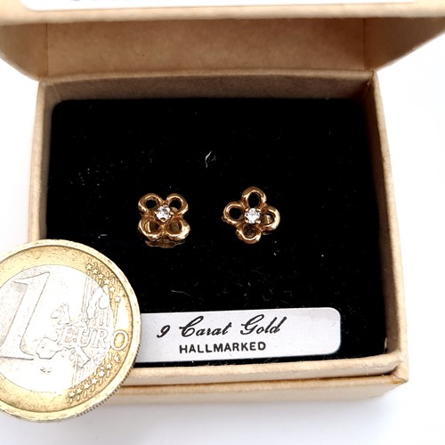 452 - A pair of 9K gold stud earrings set with diamond stone accents, total weight 1 gram.