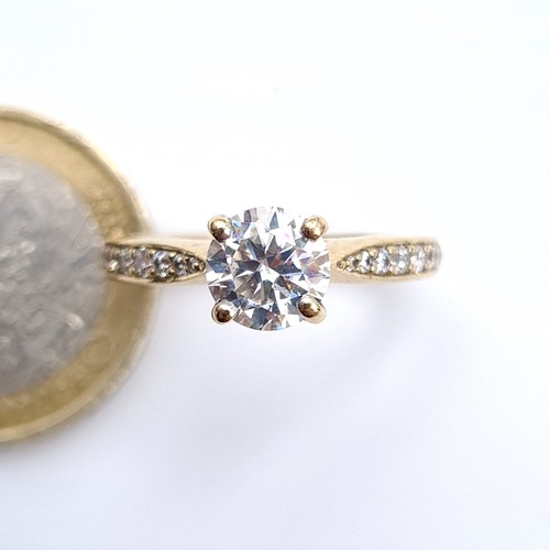 476 - Star Lot : A fine example of a moissanite solitaire ring set in 9K gold (375) with diamond set shoul... 