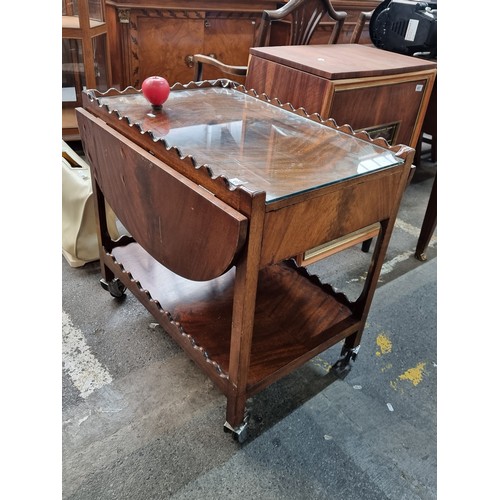 600 - A fabulous vintage wooden tea trolley with demi lune drop leaf sides and tempered glass to top. Feat... 