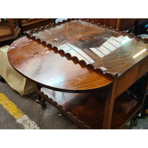 600 - A fabulous vintage wooden tea trolley with demi lune drop leaf sides and tempered glass to top. Feat... 