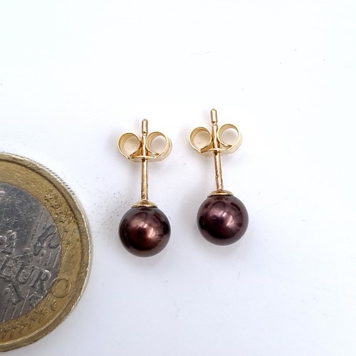 488 - A pair of black luster pearl stud earrings, set in 9K gold, total weight 1 gram.