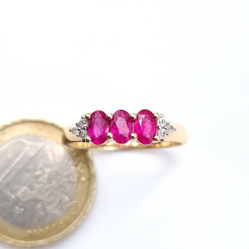 490 - Star Lot : A pretty three stone ruby ring with diamond shoulders set in 10K gold, ring size Q, weigh... 