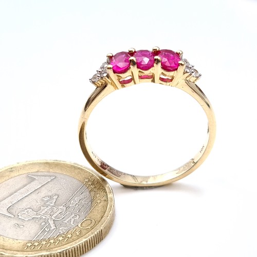 490 - Star Lot : A pretty three stone ruby ring with diamond shoulders set in 10K gold, ring size Q, weigh... 