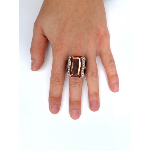 877 - A statement ring of Morganite stone with gem set surround, size P, weight 11.35 grams, boxed.