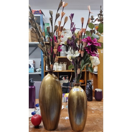 913 - A gorgeous set of two gold toned vases, both holding stylish artificial floral displays.