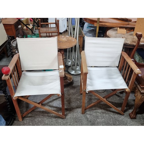 611 - A pair of director's style chairs with wooden frames and cream canvas seats.