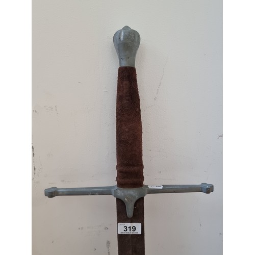 319 - A long and heavy broad sword with pewter hilt  and guard. Featuring suede handle.