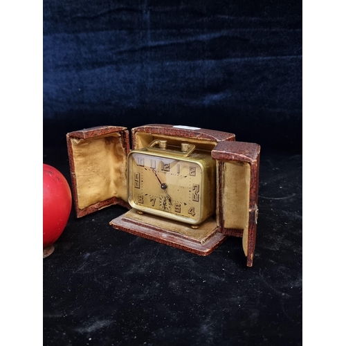 181 - An elegant French made Mid Century Brevete brass travel alarm clock with a faux leather case.