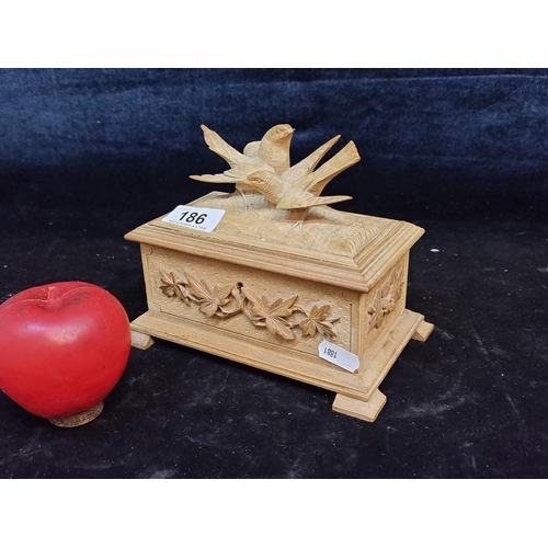 186 - A stunning hand carved wooden jewellery box boasting a bird and floral motif in relief. With red sat... 