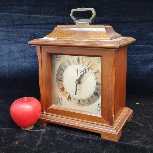 193 - A handsome mantel quartz clock from Acctim. Housed in a wooden case with glass front and brass handl... 