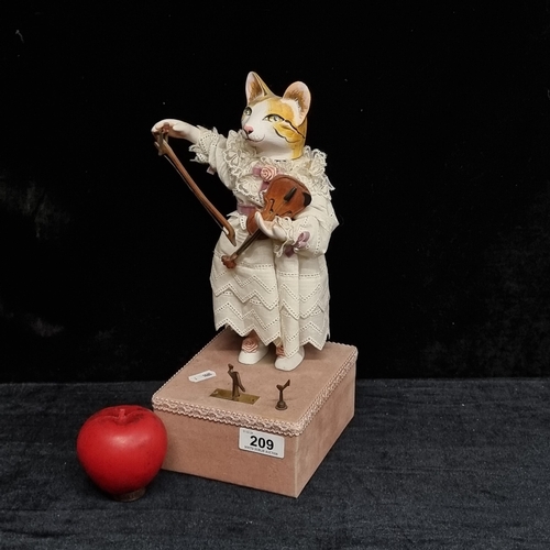 209 - A rather charming vintage  French musical figure of a cat playing the violin sat on a pink suede pli... 