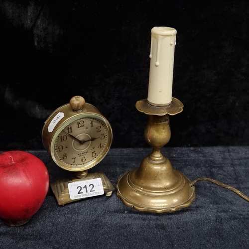 212 - Two gorgeous vintage brass items comprising of a Hy Ash Cardiff clock and a brass candle holder.