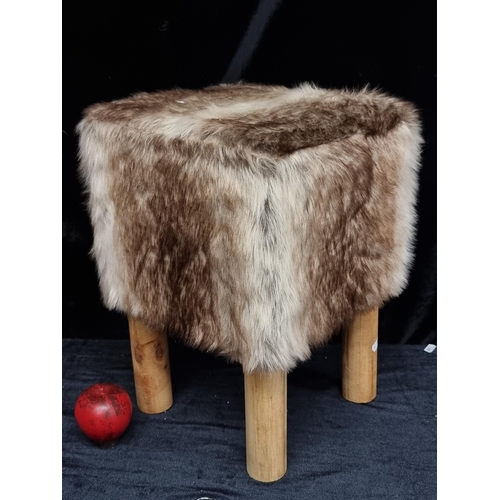 271 - A luxurious Kirkton House faux fur padded stool with wooden legs.