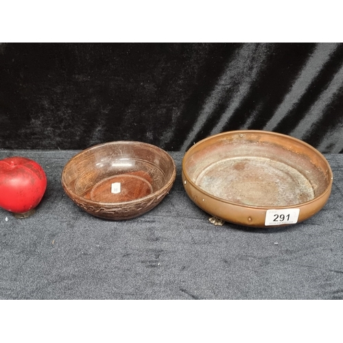 291 - A hammered copper plant saucer held on tripod feet along with a turned and carved wooden bowl.