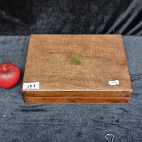 301 - An early 20th Century wooden games piece box with brass escutcheon to lid and green baize lining.