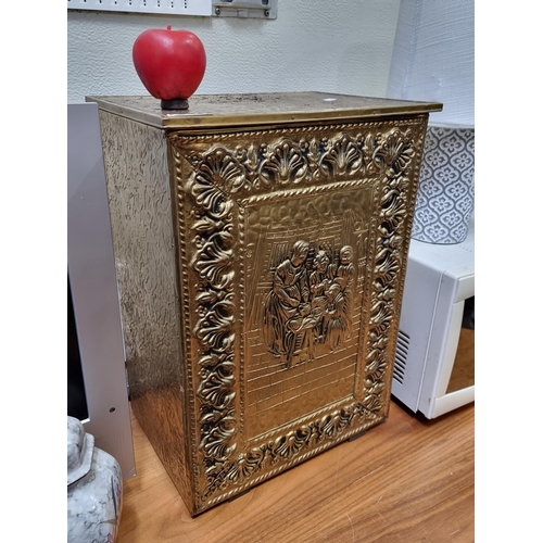 366 - a vintage brass fire box featuring a hammered figural scene to front, surrounded by foliate border. ... 