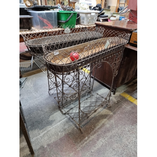 414 - Star Lot : A pair of late 19th century metal trough planters held on stands with lovely curvilinear ... 