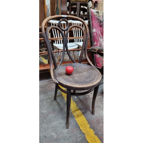 426 - A handsome example of an early 20th century bent wood bistro chair boasting a foliate design to seat... 