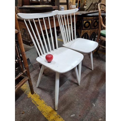 430 - A pair of timeless spindle back chairs in a white finish. In good order.  From the staff kitchen of ... 