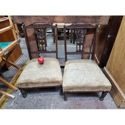 436 - A pair of fabulous Victorian low nursing chairs with elaborate carved backrests featuring a Neoclass... 