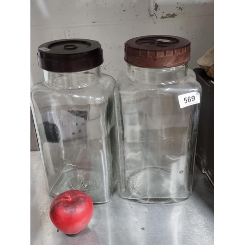 569 - A great pair of British made glass storage containers with screw top lids. Marked to base. In very g... 