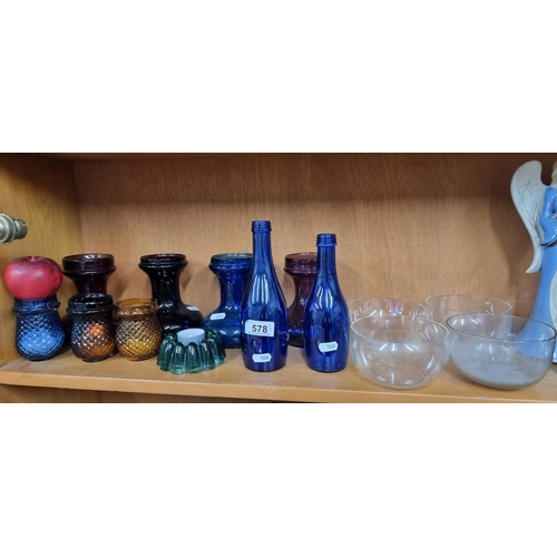 578 - A fantastic collection of coloured glass featuring hobnail cut tealight holders, blue glass bottles,... 