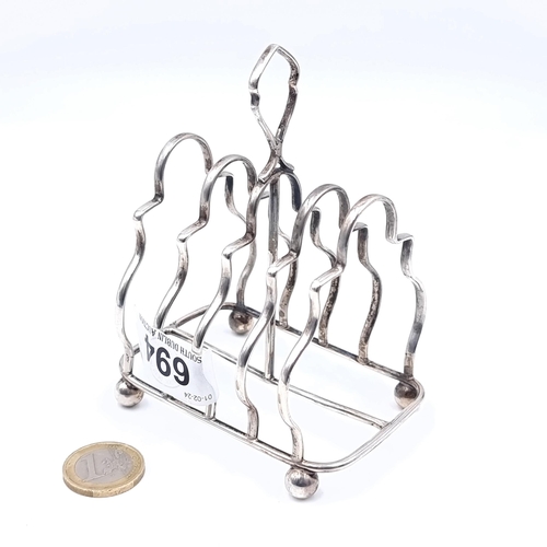 694 - A sterling silver four piece toast rack, hallmarked Birmingham, standing on four ball feet. Weight 8... 