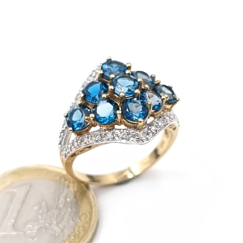 763 - Star Lot : A super quality 9K gold nine stone topaz and diamond brilliant cut ring, hallmarked Birmi... 