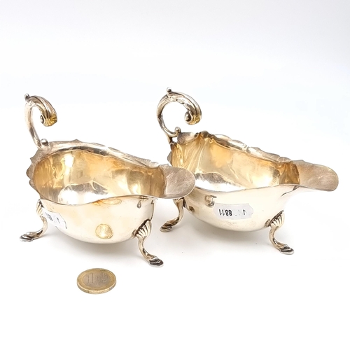 781 - Star Lot : A pair of matching sterling silver sauce boats with flying 