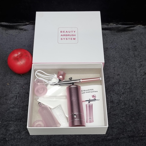 815 - A beauty airbrush system in as new condition. In a chrome pink finish. With original box.