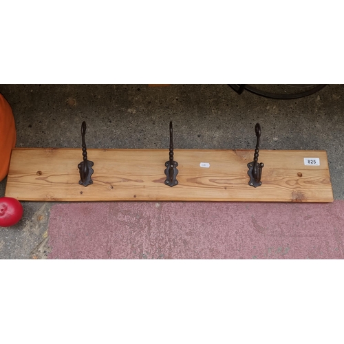 825 - A hat and coat rack comprising of three cast metal hooks.