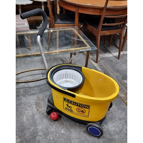 871 - A commercial sized, portable black and yellow mop bucket on wheels. Includes a fitted extended handl... 