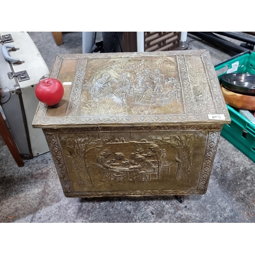 896 - A highly ornate antique wooden and brass coal box with a tavern scene in relief.